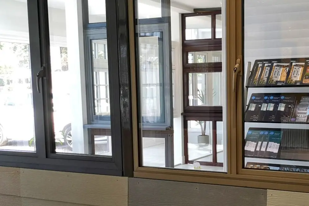 Window displays in the showroom: black, grey and oak-effect frames with a rack of brochures.