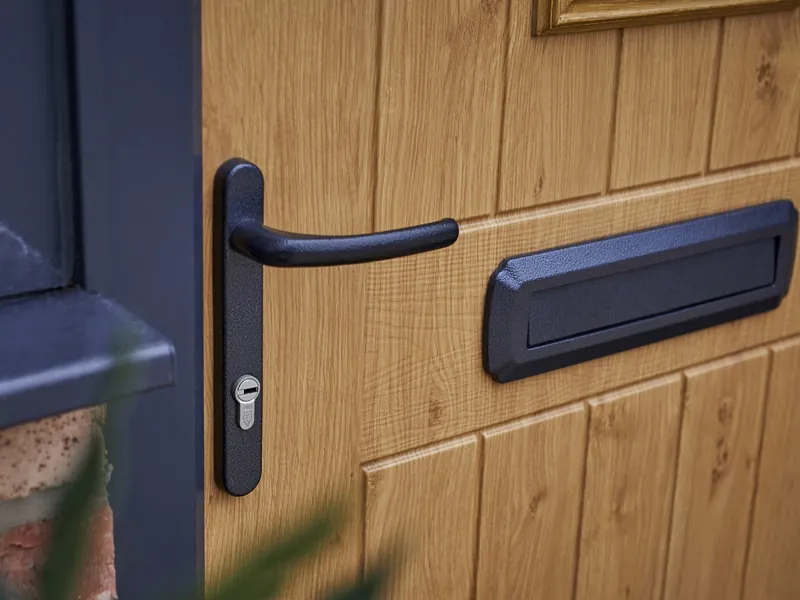 The handle and letterplate of an oak-effect Endurance door, up close.
