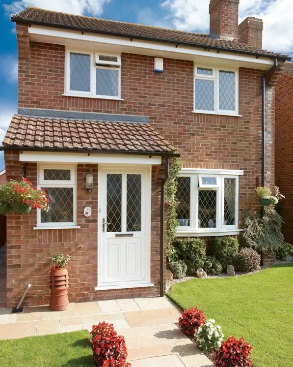 A brick semi-detached house with a white front door and matching white windows.